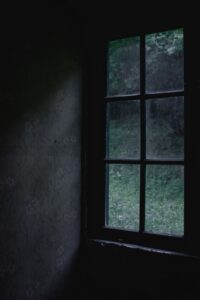 A dark room with a window Description automatically generated